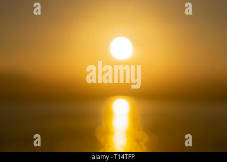 Golden astratta sfocati tramonto sull'acqua con luce trail. Foto Stock