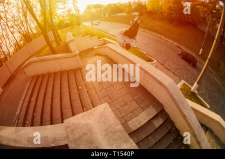 Un giovane ragazzo esegue un lato flip in autunno park. L'atleta practice parkour, formazione in condizioni di strada. Il concetto di sport sottoculture un Foto Stock