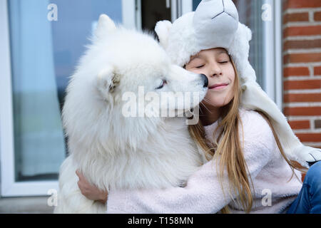 La ragazza che abbraccia il suo cane sulla terrazza Foto Stock