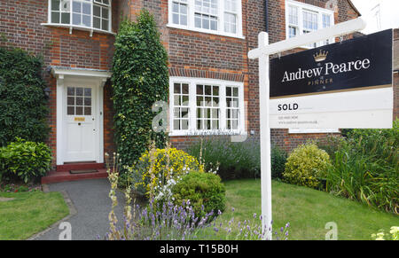 London, Regno Unito - 15 luglio 2014. A Londra - Agente immobiliare venduta segno viene visualizzata all'esterno di un suburban casa bifamiliare in Pinner, a nord-ovest di Londra. Foto Stock