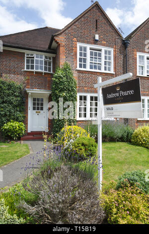 London, Regno Unito - 15 luglio 2014. A Londra - Agente immobiliare venduta segno viene visualizzata all'esterno di un suburban casa bifamiliare in Pinner, a nord-ovest di Londra. Foto Stock