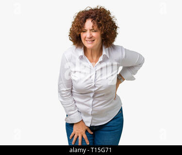 Bel mezzo ager senior businees donna sullo sfondo isolati soffrono di mal di schiena, toccando torna con la mano, dolore muscolare Foto Stock