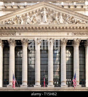 NEW YORK CITY - circa 2019: bandiere nordamericane appendere sopra l'entrata della storica New York Stock Exchange edificio nel quartiere finanziario di Manha Foto Stock