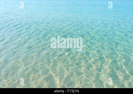 Azzurro acqua ripple sulla spiaggia sabbiosa. Acqua di mare riflessioni superficie. Tropical soleggiata giornata estiva. Foto Stock