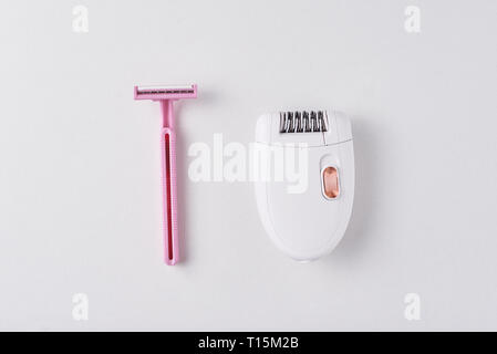 Epilatore e il rasoio per rasatura su sfondo bianco. Impostare per la depilazione, bodycare concept Foto Stock