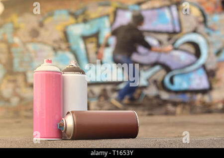 Una immagine concettuale che mostra il processo di atti di vandalismo. Il giovane uomo rovina la città di proprietà disegno illegalmente vari disegni sulle pareti. Hoo Foto Stock