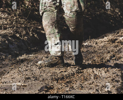 Marrone stivali militari sul fango e la pozza. Foto Stock