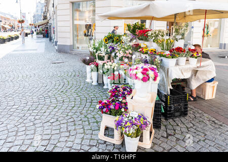 Varsavia, Polonia - Agosto 23, 2018: città vecchia strada di ciottoli marciapiede durante il giorno d'estate e di sole architettura con un fioraio negozio di fiori Foto Stock