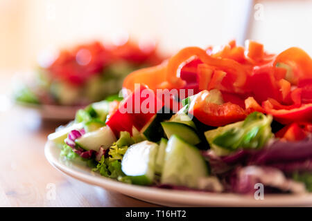 Sana vegetariano vegano il pranzo o la cena di verdura verde peperone rosso con insalata di nessuno e due piastre in sfondo bokeh di fondo Foto Stock