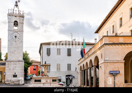 Chiusi, Italia - 25 agosto 2018: Street nel piccolo villaggio di città in Toscana durante il giorno con il municipio di bandiere nel centro storico e fontana acqua torre Foto Stock