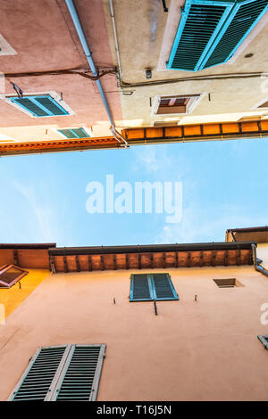 Chiusi, Italia street in piccola e antica città medievale Borgo in Toscana alla ricerca fino a basso angolo di visione durante la soleggiata giornata estiva multicolore painte colorati Foto Stock