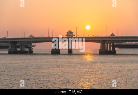 Bellissimo cielo durante il tramonto che scendono verso il mare dietro il Ponte Sarasin. Ponte Sarasin è un importante via di collegamento di terra. Foto Stock
