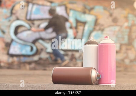 Una immagine concettuale che mostra il processo di atti di vandalismo. Il giovane uomo rovina la città di proprietà disegno illegalmente vari disegni sulle pareti. Hoo Foto Stock