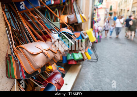 Roma, Italia molti portafoglio in pelle borse colori vibranti appesi in shopping street market nella città di Roma Foto Stock
