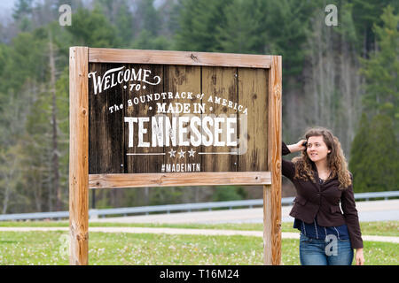 Walnut Hill, Stati Uniti d'America - 19 Aprile 2018: Benvenuti a Tennessee segno alla frontiera a durante la primavera estate con la donna viaggi turistici in piedi in posa e testo per Foto Stock