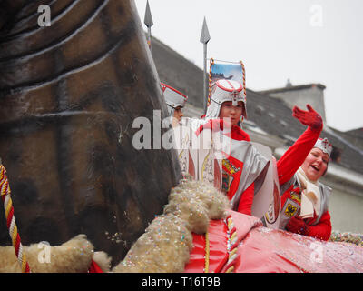 Aalst, Belgio - 27 Febbraio 2017: quattro bambini vestiti come cavalieri gettando coriandoli e a cavallo di un gigantesco cavallo chiamato "Ros Balatum' durante la carniva Foto Stock