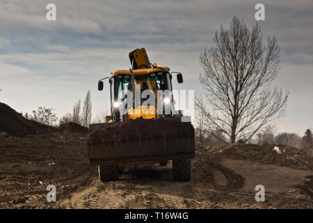 Escavatore terreno in movimento in un sito in costruzione Foto Stock