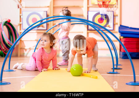 Vivaio i bambini che giocano insieme nella scuola materna di palestra Foto Stock