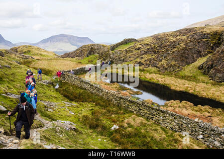 Ramblers gruppo trekking sul sentiero fino Yr Aran montagna cresta nord nelle montagne del Parco Nazionale di Snowdonia. Gwynedd, Wales, Regno Unito, Gran Bretagna Foto Stock