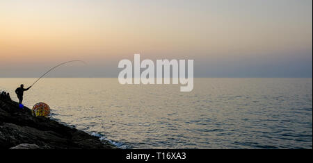 Dicembre 29, 2018 - Abu Dhabi, Emirati arabi uniti: Silhouette di un ​man pesca con una canna da pesca a sera Foto Stock