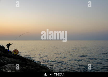 Dicembre 29, 2018 - Abu Dhabi, Emirati arabi uniti: Silhouette di un ​man pesca con una canna da pesca a sera Foto Stock