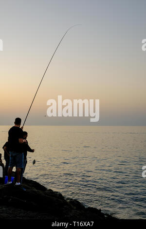 Dicembre 29, 2018 - Abu Dhabi, Emirati arabi uniti: Silhouette di un ​man pesca con una canna da pesca a sera Foto Stock