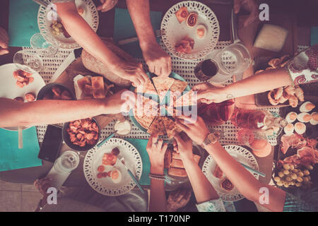 Gli amici a casa o in ristorante a mangiare tutti insieme a cena o pranzo - verticale vista dall'alto - Colori e cibo e bevande sul tavolo - Natale o Foto Stock