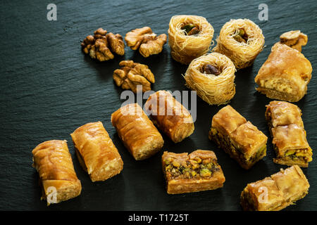Tipo diverso di arabian baklava su sfondo nero con spazio per i tipi di testo - nido borma ush-el-bul-bul asabi Foto Stock