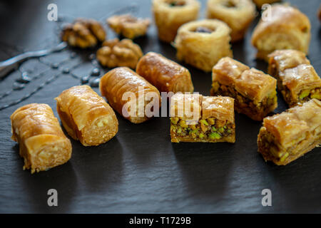 Tipo diverso di arabian baklava su sfondo nero con spazio per i tipi di testo - nido borma ush-el-bul-bul asabi Foto Stock