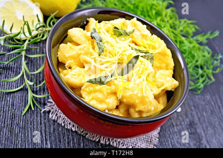 Gnocchi di zucca con salvia, limone, il formaggio e il burro in una ciotola, tela, forcella sulla tavola di legno sfondo Foto Stock