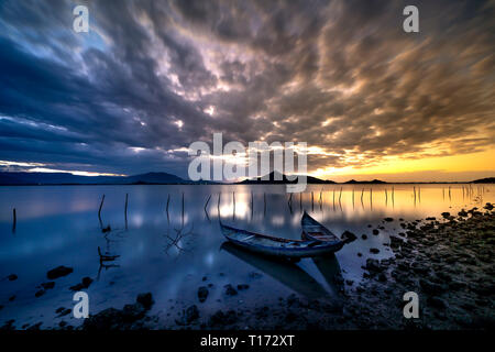 Bellissima alba presso la laguna con la barca il focus principale. Il concetto di sensazione di Solitario Foto Stock