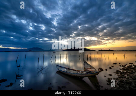 Bellissima alba presso la laguna con la barca il focus principale. Il concetto di sensazione di Solitario Foto Stock