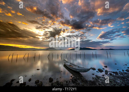 Bellissima alba presso la laguna con la barca il focus principale. Il concetto di sensazione di Solitario Foto Stock