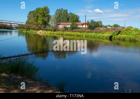 Sospensione ponte sopra il fiume Msta su un giorno d'estate. Città Borovichi, Russia Foto Stock