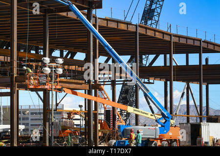 LAS VEGAS, NEVADA, STATI UNITI D'AMERICA - Febbraio 2019: un 'cherry picker' sollevamento idraulico piattaforma essendo utilizzato per raggiungere la parte superiore del lavoro di acciaio su un sito in costruzione Foto Stock