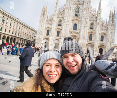 Viaggi, Italia e divertente giovane concetto - Happy turisti prendendo un autoritratto con piccioni nella parte anteriore del Duomo di Milano Foto Stock