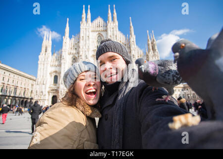Viaggi, Italia e divertente giovane concetto - Happy turisti prendendo un autoritratto con piccioni nella parte anteriore del Duomo di Milano Foto Stock