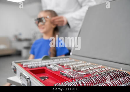 Close up di speciali, professional oculista attrezzature, caso con lenti. Oculista esaminando, controllare la vista del paziente in Clinica Medica. Foto Stock