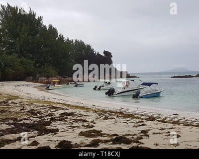 Barche sulla costa dell'isola tropicale Curieuse sulle Seychelles Foto Stock