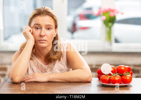 Coppia bionda donna seduta al tavolo avente allergia alimentare Foto Stock