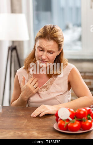 Donna bionda con allergia avente rash sul suo corpo di graffiare la pelle Foto Stock