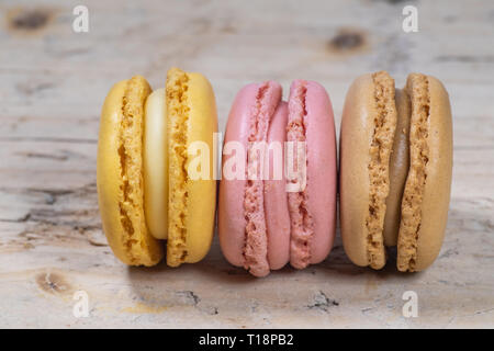 Colorati macarons francesi isolati su legno vecchio sfondo texture. Colori pastello - Imagen Foto Stock