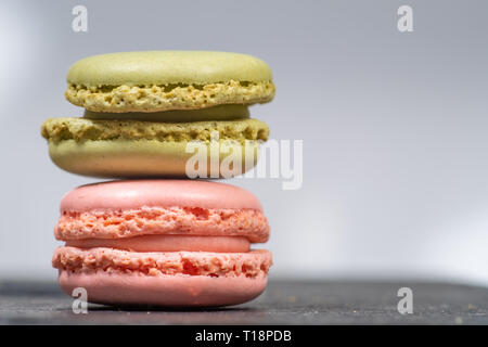 Assortiti francese colorati macarons isolati su sfondo bianco posto su una pietra ardesia. Colori pastello - Immagine Foto Stock