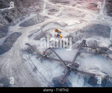 Vista panoramica al tramonto della cava di ghiaia, miniere di costruzione gialla ghiaia, ghiaia di pompaggio con l aiuto di potenti pompe, post-apocalittico landscap Foto Stock