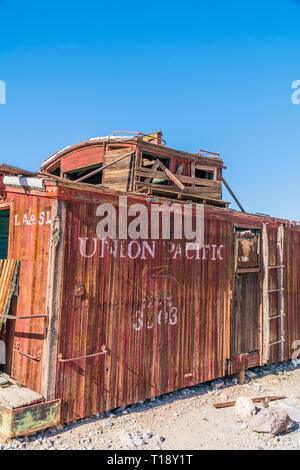 Un abbandonato, ruota-meno della Union Pacific caboose decadendo nel deserto di Mojave città fantasma di riolite. Un caboose è un presidiati North American vagoni ferroviari Foto Stock