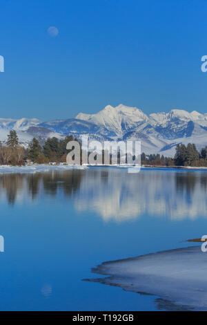 Luna crescente oltre il fiume flathead e missione le montagne in inverno vicino a Dixon, montana Foto Stock