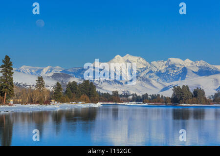 Luna crescente oltre il fiume flathead e missione le montagne in inverno vicino a Dixon, montana Foto Stock