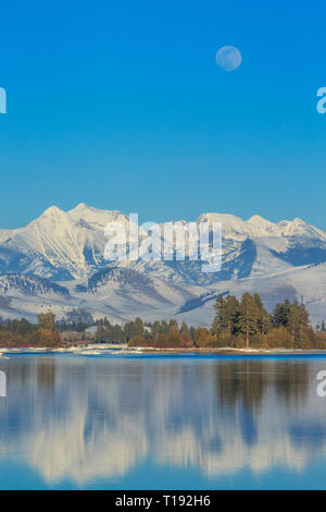 Luna crescente oltre il fiume flathead e missione le montagne in inverno vicino a Dixon, montana Foto Stock