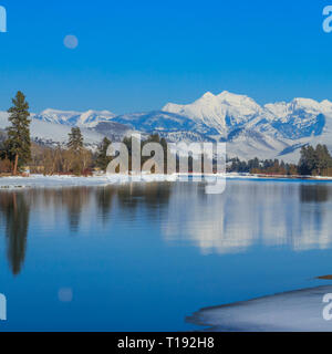 Luna crescente oltre il fiume flathead e missione le montagne in inverno vicino a Dixon, montana Foto Stock