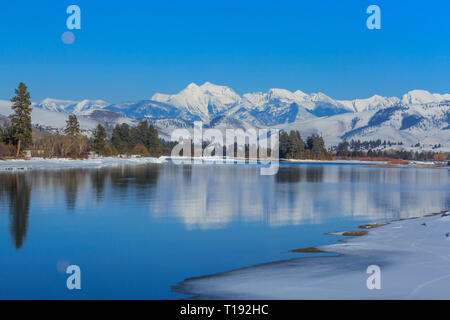 Luna crescente oltre il fiume flathead e missione le montagne in inverno vicino a Dixon, montana Foto Stock